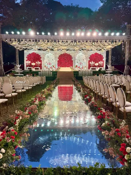 A wide view of the entire ceremony setup, with the magnificent stage, reflective aisle, and elegant guest seating.
