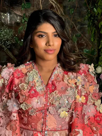 A portrait from a birthday photoshoot. The soft, shimmering makeup enhances her features and complements the beautiful colors in her floral outfit.