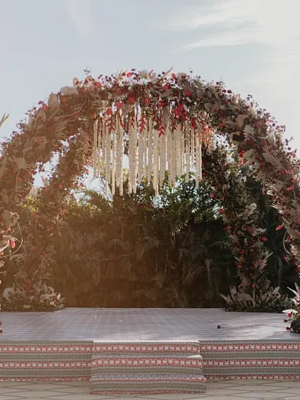 This is the mandap of my dreams. Inspired by the timeless elegance of Sabyasachi, we created this breathtaking arch with a dense canopy of red and maroon florals, pampas grass, and a stunning chandelier of white tuberoses. It was regal, rustic, and everything the couple envisioned for their sacred vows.