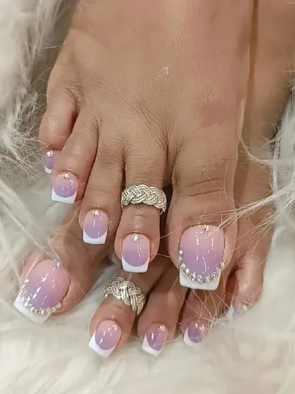 We provide detailed pedicures to match your manicure. This look features a beautiful purple and white ombre on the toenails, finished with a border of sparkling rhinestones.