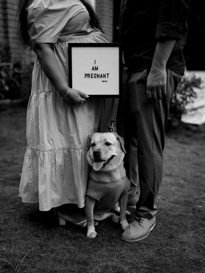 A fun family announcement including their dog. The "I am Pregnant" sign is simple and direct, and the dog's presence makes it a portrait of the whole family.