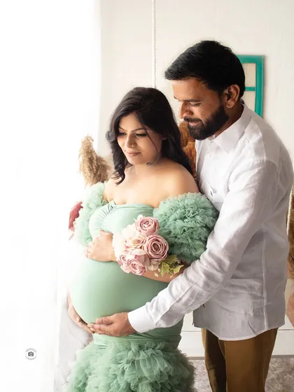 A gentle and loving moment between parents-to-be. This candid shot by the window uses natural light to create a soft and beautiful image.