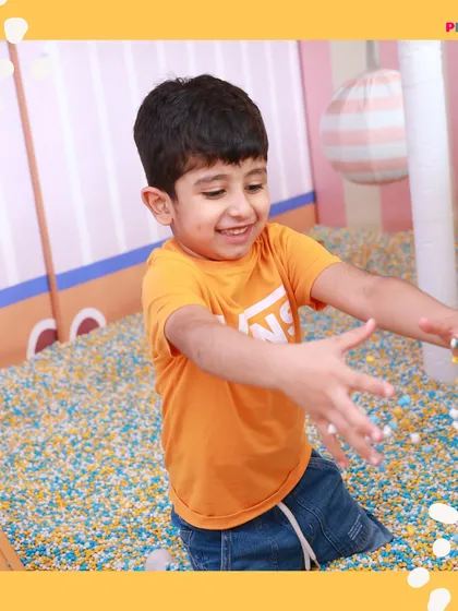 This little one is all smiles while playing in our sensory pit, filled with soft, textured grains for a unique tactile experience.