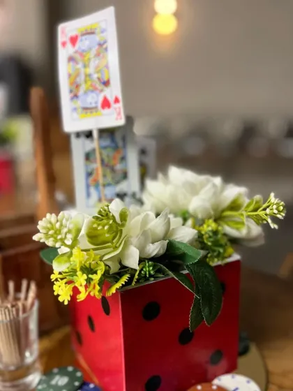 It's all in the details. A custom centerpiece for the Casino Night party, featuring a dice-shaped vase, playing cards, and poker chips.