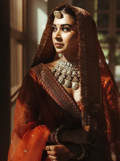 The sunlight catching the bride's features beautifully, highlighting the warm tones of her makeup.