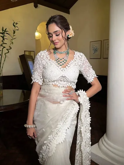 A full-length view of the white lace saree. The intricate lace border and matching blouse create a cohesive and luxurious look.