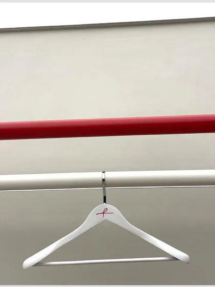 A minimalist shot focusing on the brand's identity, with the custom hanger and the signature red display rod.