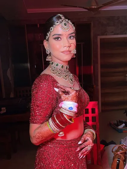 A candid getting-ready shot, showing the final touches. The bride's chooda and henna are as much a part of the look as the makeup, and I ensure everything is perfect.