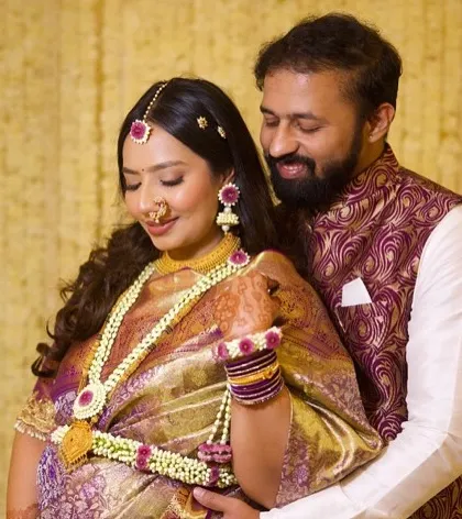 A beautiful moment between the expecting couple. Her makeup is flawless, and her smile radiates happiness.