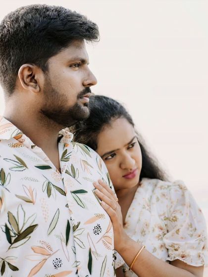 A tender close-up shot of a couple on the beach, capturing a quiet, emotional moment between them.