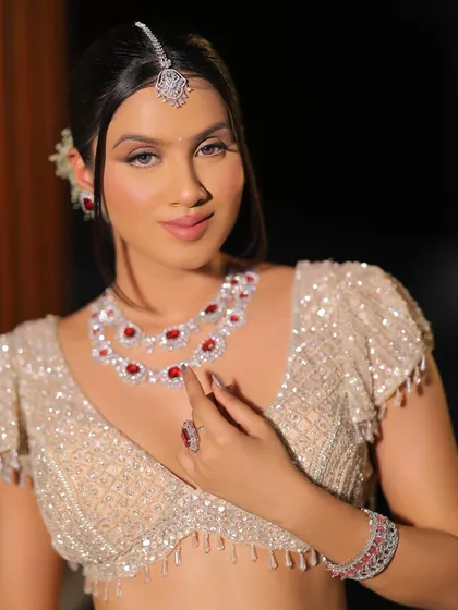 A confident pose showing off the stunning ruby and diamond necklace. The makeup is kept soft and neutral to let the jewelry make a statement.