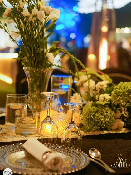 Another beautiful detail of the place setting, with the soft glow of candles reflecting in the crystal-clear wine glasses.