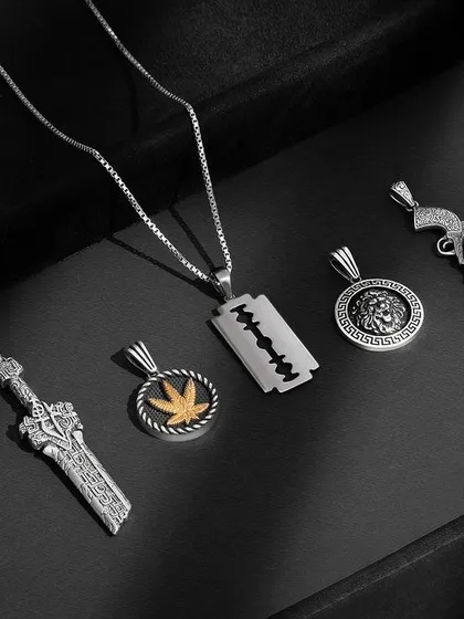 A collection of cool and edgy men's pendants. We shot these with moody lighting and a dark background to bring out a masculine vibe, highlighting unique designs like the razor blade, sword, and lion head.