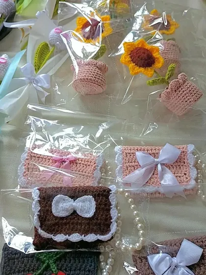 A collection of cute crochet pocket purses with pearl handles and bow details, made for a college fest.