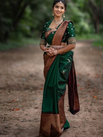 A full-length shot of the green and brown saree, its rich colors perfect for an outdoor setting.