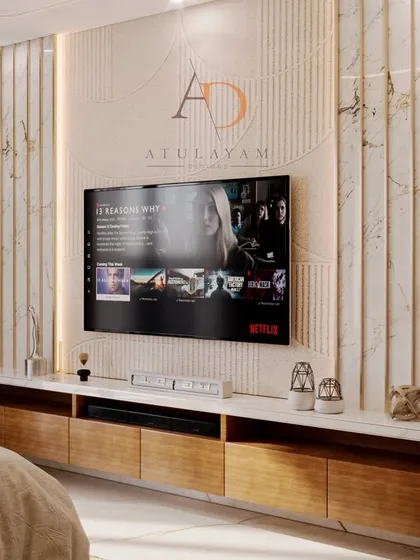 The TV wall in this bedroom is a statement piece, with fluted marble paneling, gold accents, and a floating wooden console for a clean, modern look.