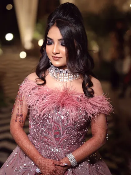 The full look, showcasing the feathered gown and the dramatic makeup. This is for the bride who is not afraid to experiment and wants a truly unique look.