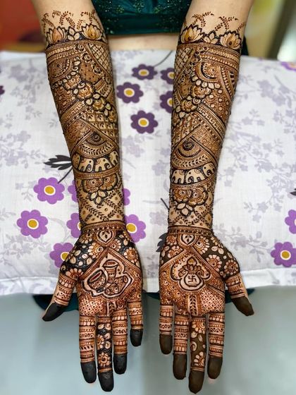 This design features auspicious kalash and swastika symbols on the palms, with elephant motifs and traditional patterns on the arms.