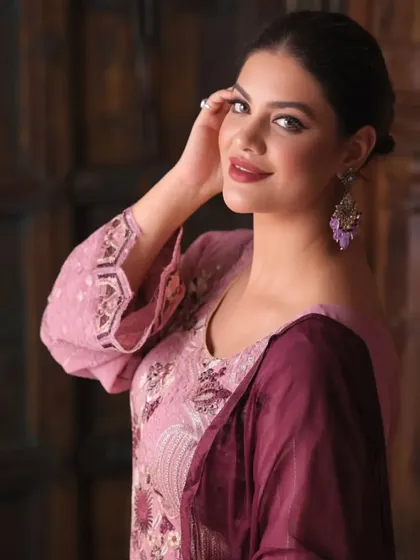 A close-up portrait that highlights the model's makeup and the elegant earrings that complement the traditional outfit.