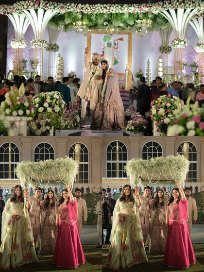A beautiful moment from the Varmala ceremony, with the bridesmaids holding a 'phoolon ki chaadar' of baby's breath, all set against the grand wedding stage.