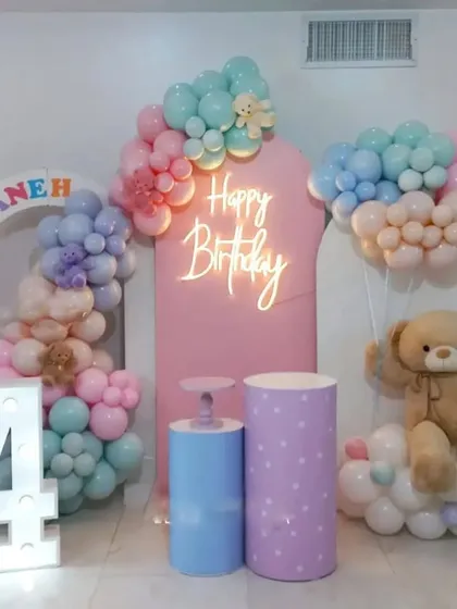 A teddy bear themed 4th birthday party. This decoration features pastel balloon clouds, a large teddy bear prop, and a marquee number '4'.