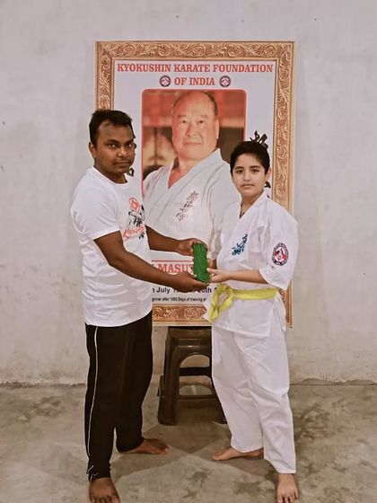 Presenting a new green belt to a student. This is an important milestone in her karate journey.