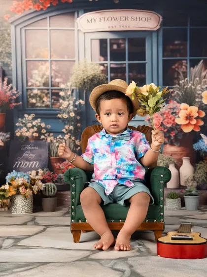 A sweet moment with the birthday boy holding a bouquet of flowers, perhaps for his mom. A heartwarming shot from his first birthday session.