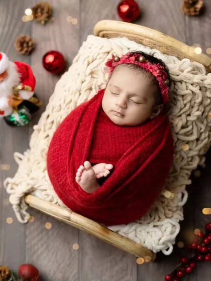 Our full Christmas newborn setup, with a tiny Santa, festive berries, and twinkling lights creating a magical holiday scene.