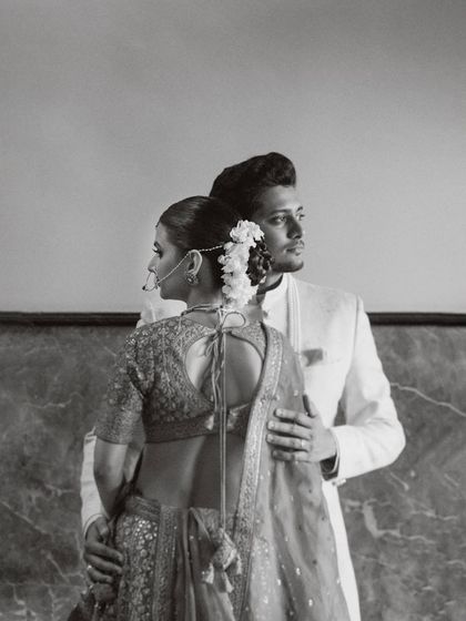 A classic, elegant portrait in black and white. The groom's hand gently on his bride's back, their gazes directed differently yet connected. This image showcases my approach to creating timeless, architectural portraits that feel like fine art.