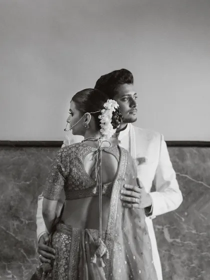 A classic, elegant portrait in black and white. The groom's hand gently on his bride's back, their gazes directed differently yet connected. This image showcases my approach to creating timeless, architectural portraits that feel like fine art.