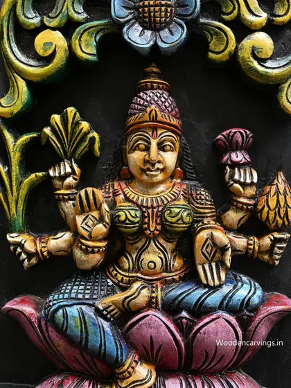 This close-up highlights a goddess holding a sheaf of paddy, symbolizing agricultural wealth. The painting style is traditional and vibrant, staying true to South Indian artistic conventions.