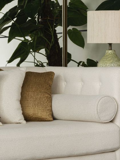 A close-up on the sofa styling, where a mix of velvet, linen, and embroidered cushions are arranged to create a look that feels collected and personal.