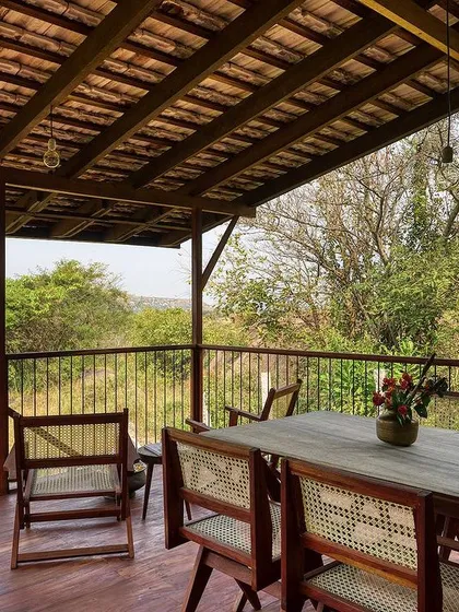 The spacious wooden deck serves as an outdoor dining and living room, extending the usable area of the small cottage.
