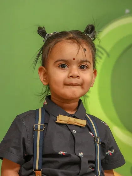 Capturing personality is key, especially for kids' photoshoots. This is a close-up portrait from a first birthday party, where the focus is on the child's fun expression and adorable outfit, complete with a bow tie and suspenders.