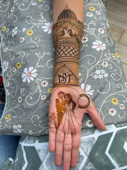 A perfect example of combining personal stories with traditional art. This design features a custom couple portrait on the palm, complemented by a beautiful architectural design on the arm with peacocks and custom initials.