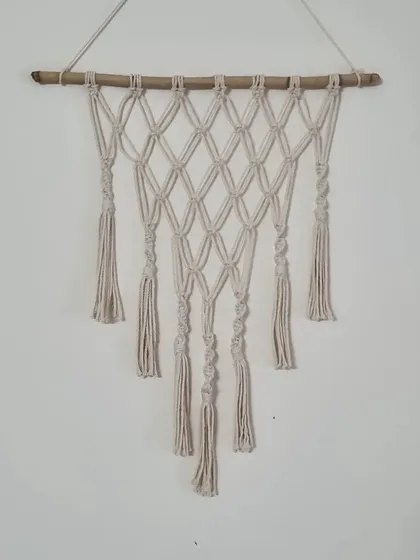 A simple yet elegant macrame wall hanging featuring a diamond pattern and spiraling knots. It's a versatile piece that fits beautifully in any space.