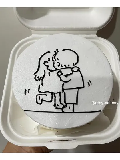 A heartwarming bento cake design showing a simple line-art drawing of two people hugging.