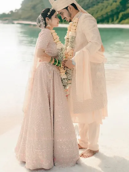 A serene beach portrait. We capture the couple in a loving embrace against the backdrop of the calm sea and distant hills, perfect for a destination wedding.