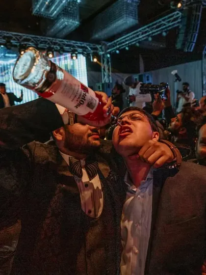 The party is in full swing as a guest takes a drink straight from the bottle. We encourage a fun, carefree atmosphere at every event we serve.