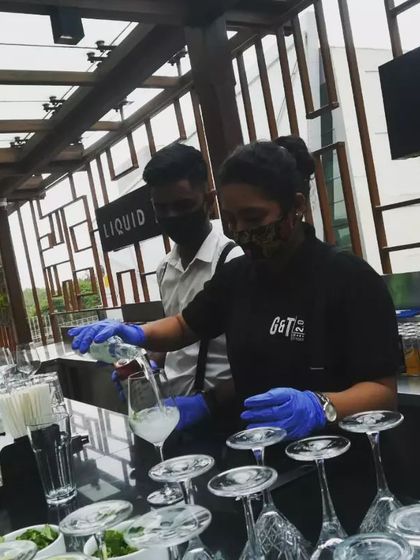 We celebrate our super women in bartending. Here, one of our professional female bartenders is carefully pouring a drink, showcasing the skill and dedication of our entire team.