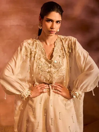 A powerful pose in the Orion Kaftan Set. The intricate embroidery on the neckline and the relaxed silhouette of the kaftan and dhoti pants create a look of effortless style.