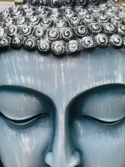 Another example of a custom-painted Buddha statue. This one has a beautiful light blue finish with a distressed, brushed effect, giving it a unique, artistic look.