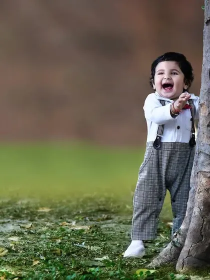 Another angle of the little boy playing peek a boo, capturing his excited expression and open mouthed laugh.