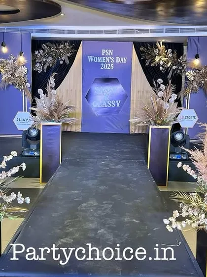 We design the entire guest experience, starting from the entrance. For this corporate Women's Day event, we created a formal entryway with a black carpet runner, flanked by large boho-style arrangements of pampas grass leading to the main stage.