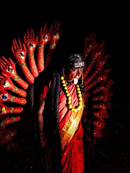 A striking depiction of a devotee as the multi-armed goddess Kali, a powerful and dramatic costume that is central to the Kulasai celebrations.