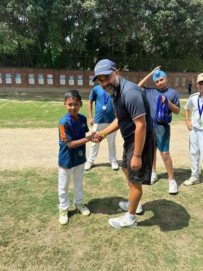 A handshake of congratulations between a coach and a junior player. Every medal is a reward for dedication and hard work during the tournament.