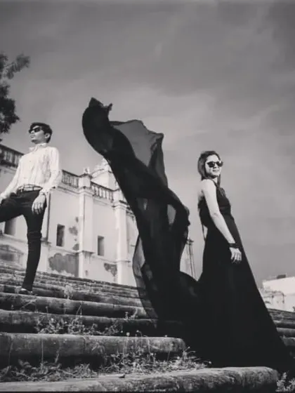 A high-fashion, dramatic black and white shot of a couple on old stone steps, creating a very stylish look.