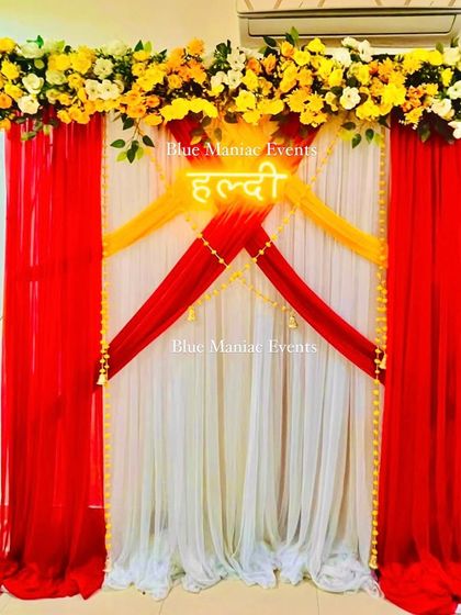 Another shot of the red and yellow Haldi backdrop, showing the 'Haldi' neon sign that adds a modern touch.