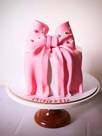 A beautiful pink version of the sculpted bow cake, with delicate pearl details on the bow. This shows how the design can be customized with different colors.