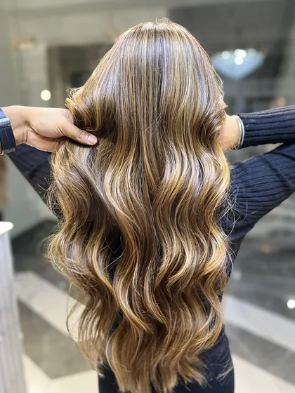 A stunning example of a golden-blonde balayage. The highlights are strategically placed to frame the face and add brightness.